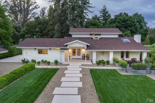 view of front of house featuring french doors and a front lawn