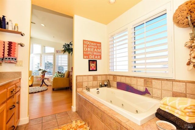 bathroom with vanity, tiled bath, and tile patterned flooring