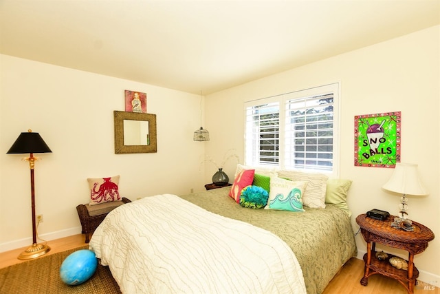 bedroom with light wood-type flooring and baseboards