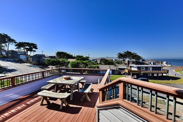 wooden deck featuring a residential view and a water view
