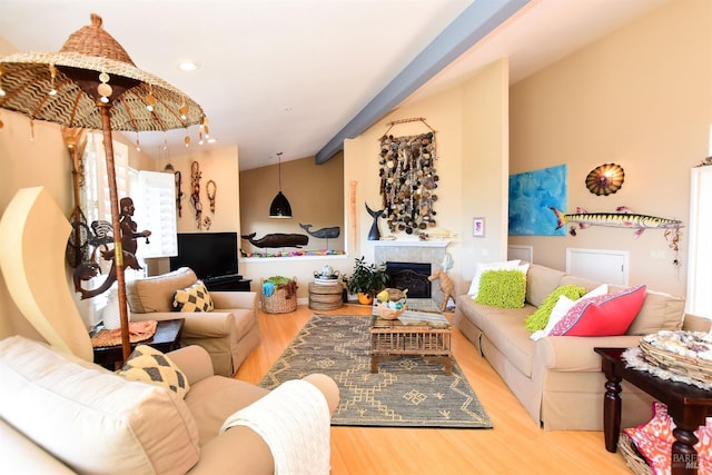 living room featuring light hardwood / wood-style floors, vaulted ceiling, and a high end fireplace