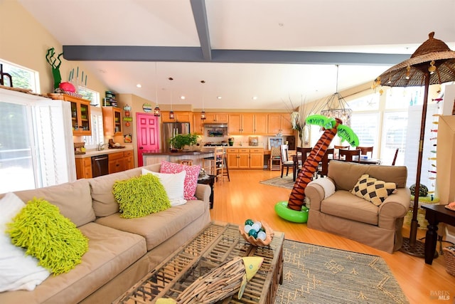 living room with light hardwood / wood-style flooring and lofted ceiling with beams