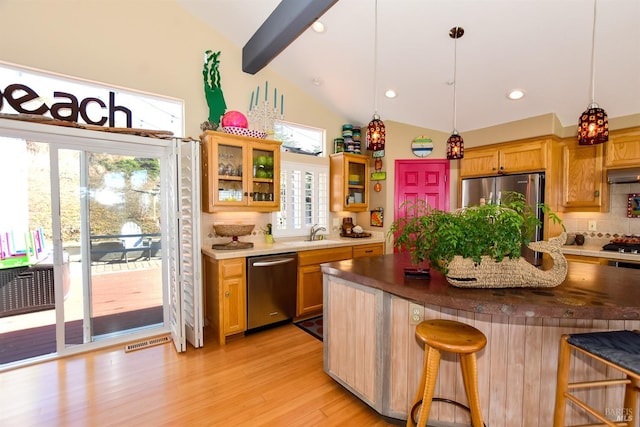 kitchen with a kitchen breakfast bar, light hardwood / wood-style flooring, stainless steel appliances, pendant lighting, and tasteful backsplash