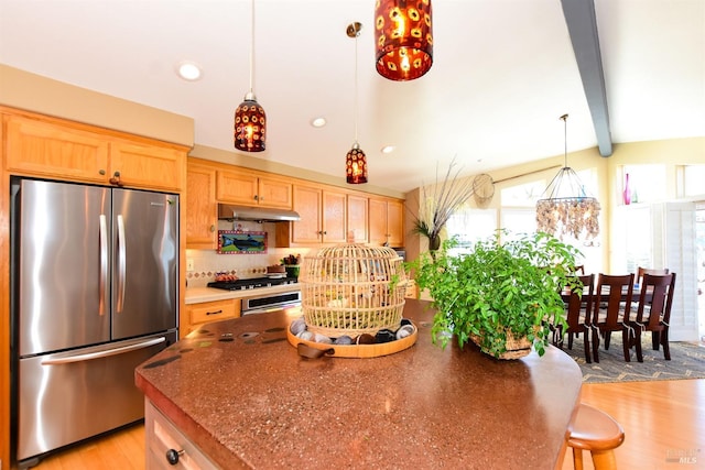 kitchen featuring tasteful backsplash, appliances with stainless steel finishes, lofted ceiling with beams, decorative light fixtures, and light hardwood / wood-style flooring