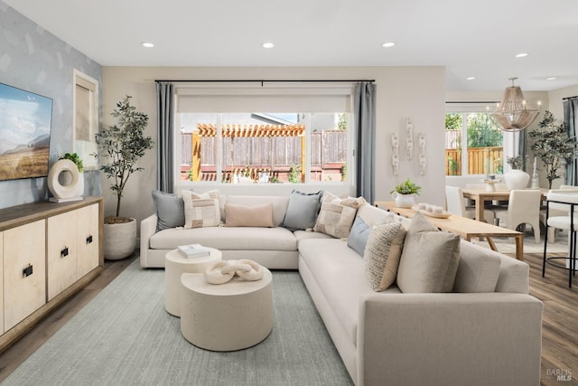 living room with hardwood / wood-style floors, a healthy amount of sunlight, and a chandelier