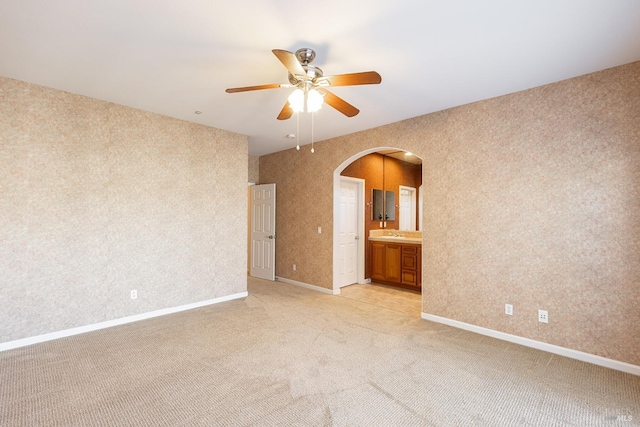 carpeted empty room featuring sink and ceiling fan