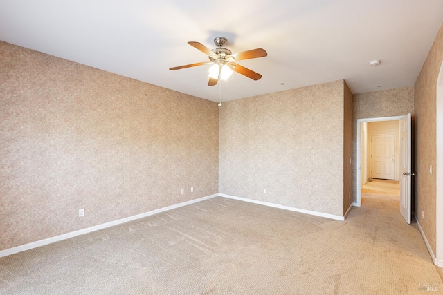 unfurnished room with light colored carpet and ceiling fan