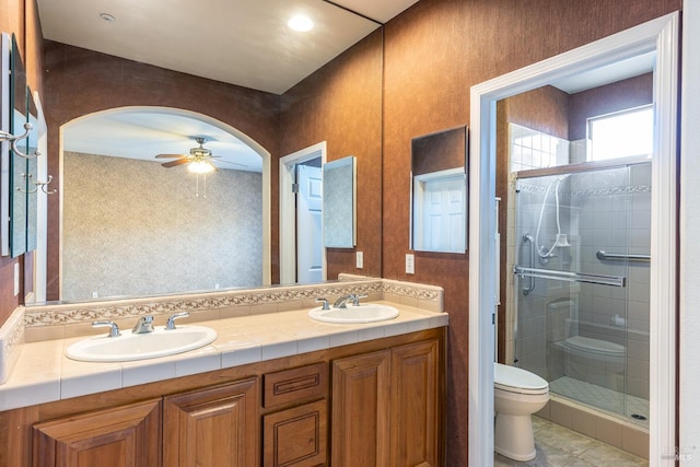 bathroom with an enclosed shower, toilet, ceiling fan, tile patterned floors, and vanity