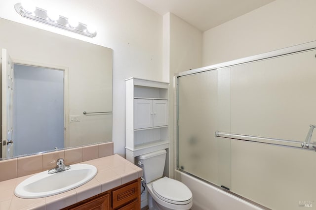 full bathroom with toilet, vanity, and shower / bath combination with glass door