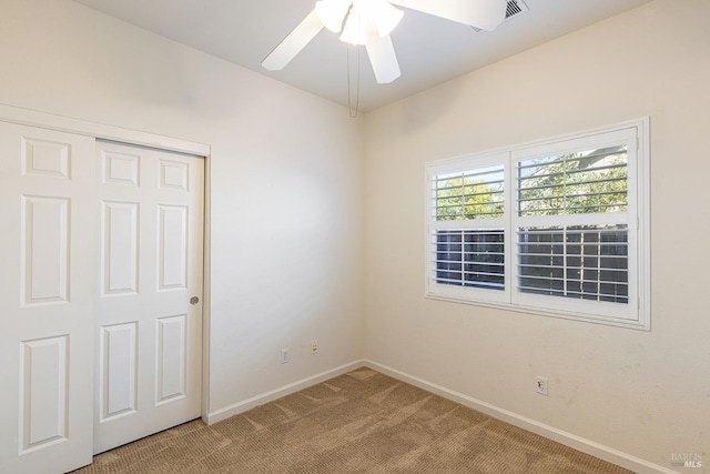 spare room featuring ceiling fan and light colored carpet