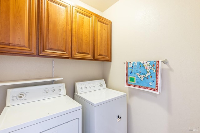 clothes washing area featuring washer and clothes dryer and cabinets