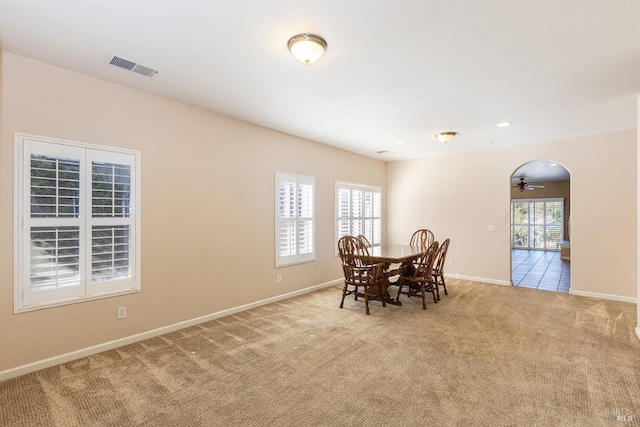 dining space with light colored carpet and ceiling fan