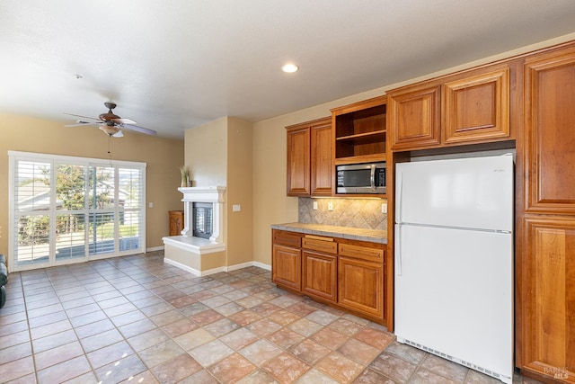 kitchen featuring decorative backsplash, white fridge, light tile patterned floors, and ceiling fan