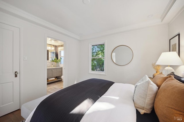 bedroom with ornamental molding, wood finished floors, and connected bathroom