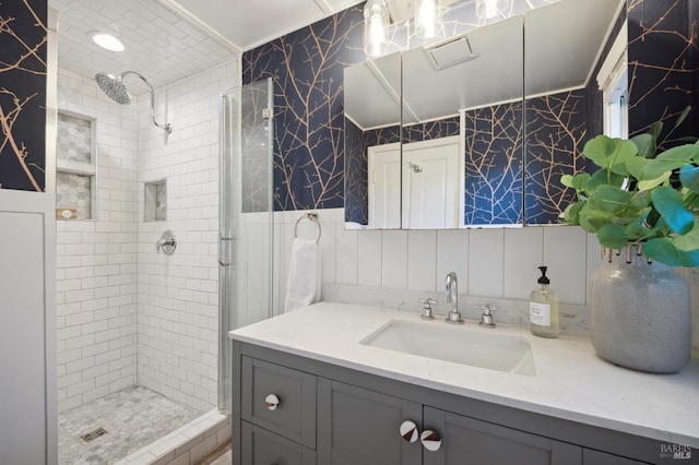 full bathroom featuring vanity, a shower stall, and tile walls