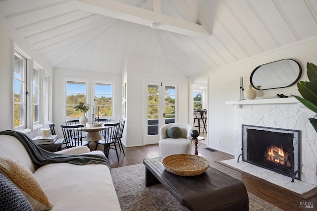 sunroom featuring lofted ceiling with beams, a fireplace, visible vents, and french doors