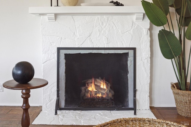 room details featuring a lit fireplace and wood finished floors