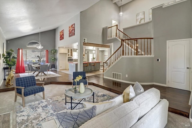 living room featuring a wealth of natural light, hardwood / wood-style flooring, and high vaulted ceiling