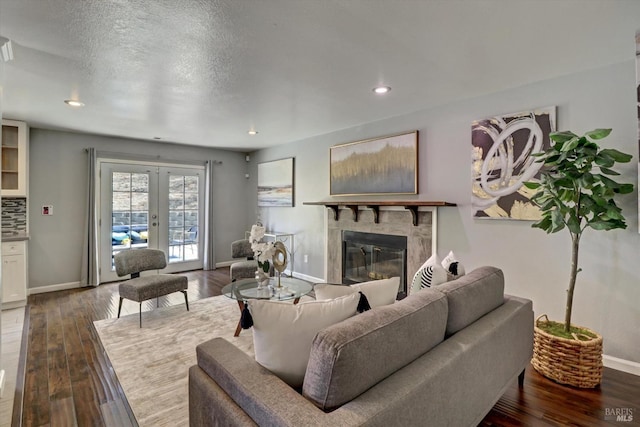 living room with dark wood-type flooring, a textured ceiling, and french doors