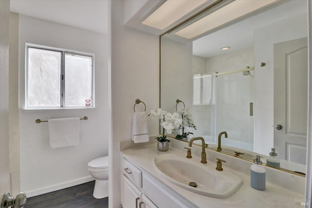 bathroom with hardwood / wood-style floors, toilet, vanity, and an enclosed shower