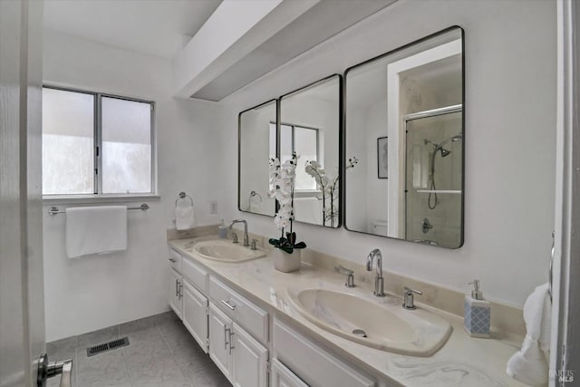 bathroom featuring tile patterned flooring, a shower with shower door, and vanity