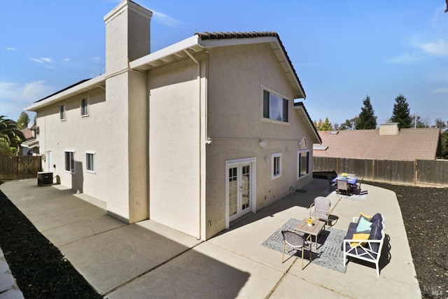 rear view of house featuring a patio area, central air condition unit, and french doors