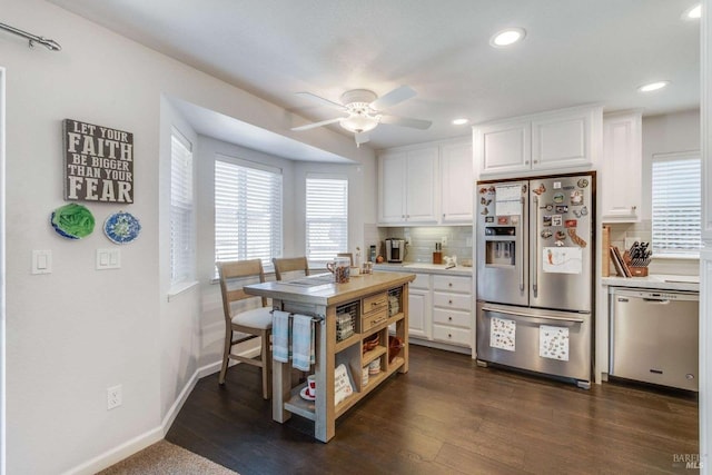 kitchen featuring appliances with stainless steel finishes, white cabinetry, ceiling fan, and dark hardwood / wood-style flooring