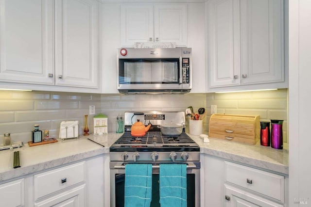 kitchen featuring light stone countertops, white cabinets, and stainless steel appliances