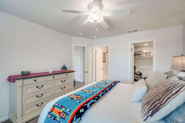 bedroom featuring a closet, ceiling fan, carpet flooring, and a walk in closet