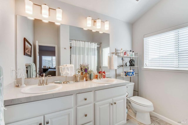 bathroom featuring vanity, toilet, tile patterned floors, and lofted ceiling