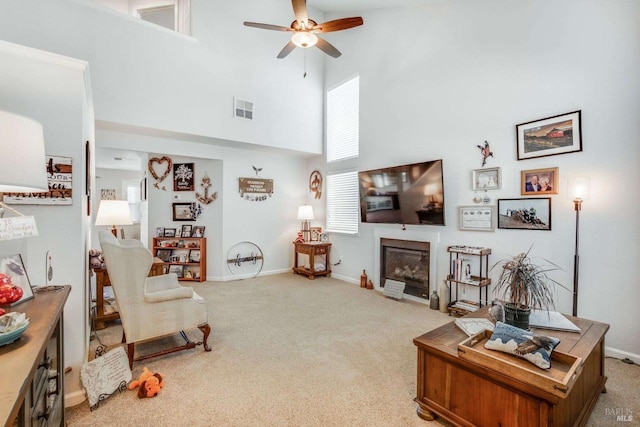 carpeted living room featuring a high ceiling and ceiling fan