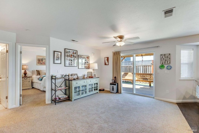 living room featuring carpet floors, a textured ceiling, and ceiling fan