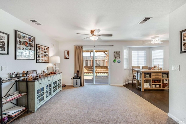 sitting room featuring a textured ceiling, carpet floors, and ceiling fan