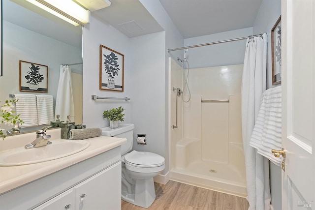 bathroom with vanity, toilet, walk in shower, and hardwood / wood-style floors