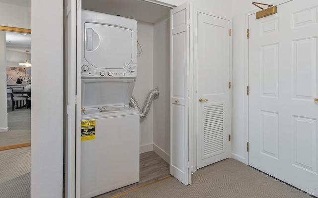 laundry area featuring light hardwood / wood-style flooring and stacked washer and clothes dryer