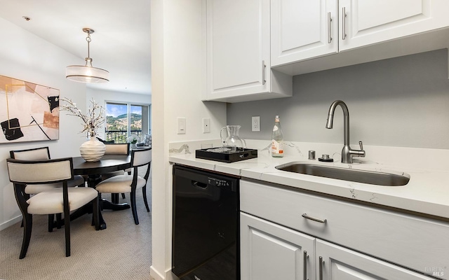 kitchen featuring black dishwasher, sink, white cabinets, and decorative light fixtures