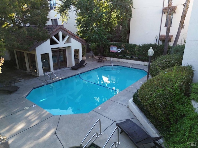 view of swimming pool featuring a patio area and an outbuilding