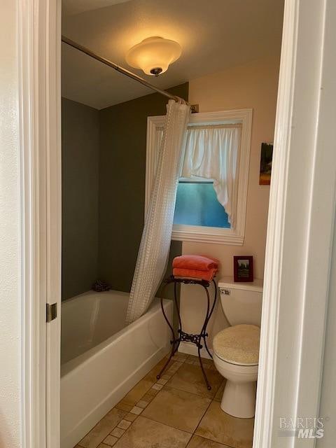 bathroom featuring tile patterned floors, toilet, and shower / bathtub combination with curtain