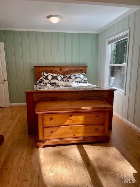 bedroom with light hardwood / wood-style floors and crown molding