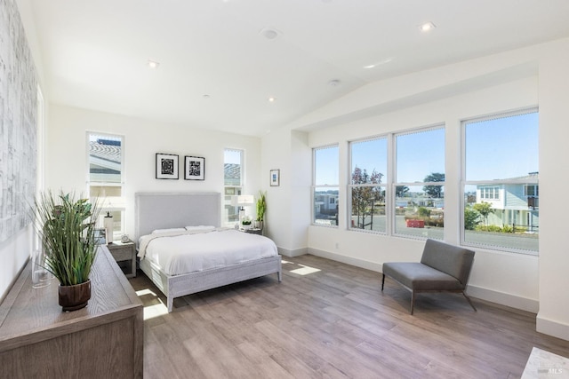 bedroom featuring light hardwood / wood-style floors and lofted ceiling