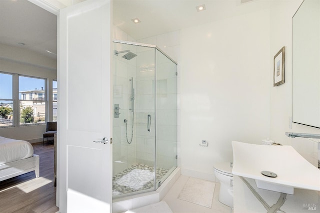 bathroom with toilet, lofted ceiling, a shower with shower door, and wood-type flooring