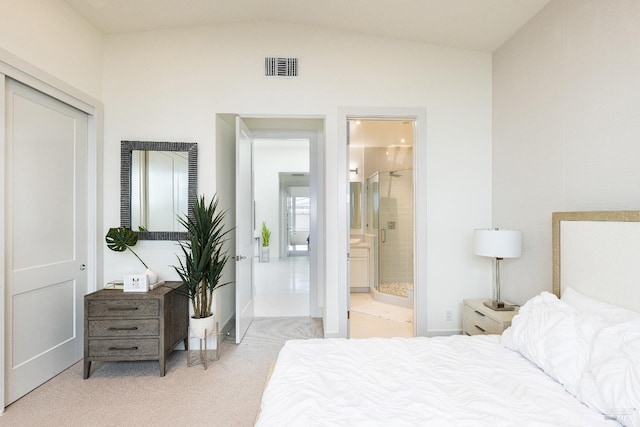 carpeted bedroom with connected bathroom and lofted ceiling