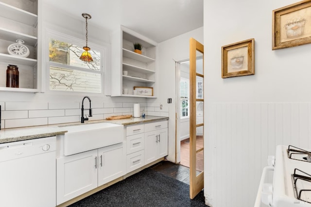 kitchen featuring white dishwasher, decorative light fixtures, white cabinets, and sink