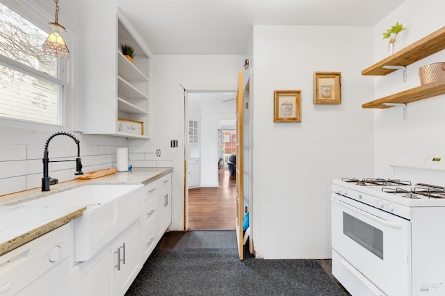 kitchen featuring white appliances, dark wood-type flooring, decorative light fixtures, light stone counters, and white cabinetry