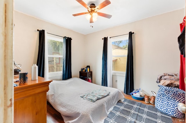 bedroom with hardwood / wood-style flooring, multiple windows, and ceiling fan