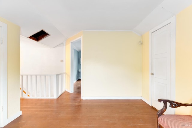 empty room featuring hardwood / wood-style floors and vaulted ceiling