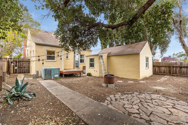 rear view of property with central AC unit