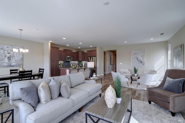 living room featuring light hardwood / wood-style floors and a chandelier