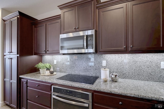 kitchen with dark brown cabinets, appliances with stainless steel finishes, backsplash, and light stone countertops