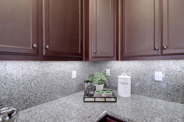 interior details featuring light stone countertops and decorative backsplash